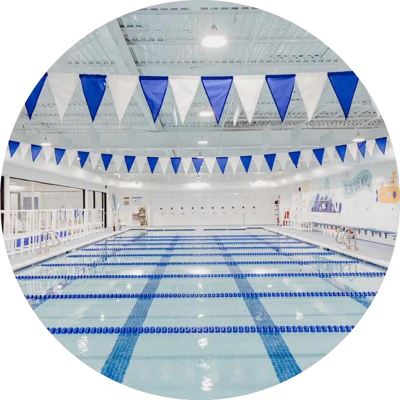 indoor pool with lane lines and Big Blue Swim School flag banner